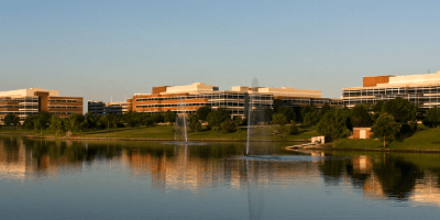 Paisaje de los edificios principales de State Farm frente a una gran laguna.