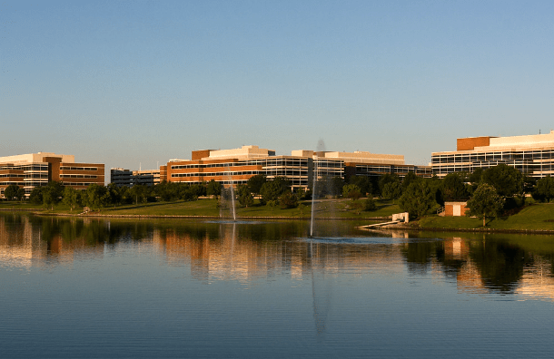 Paisaje de los edificios principales de State Farm frente a una gran laguna.
