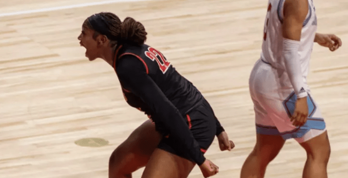Una mujer celebrando en una cancha de baloncesto.