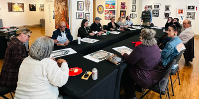 Varias personas sentadas alrededor de una mesa rectangular.