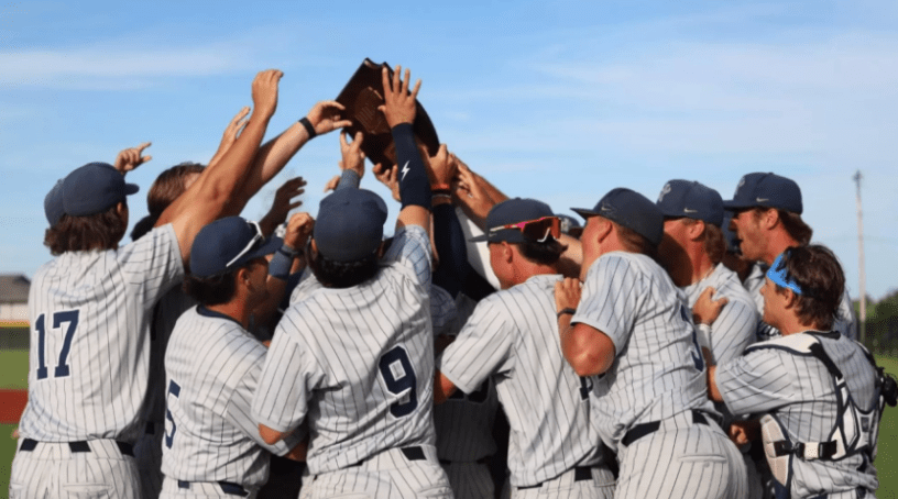 Jugadores del equipo de beisbol de HCC chocando sus manos para celebrar la victoria.