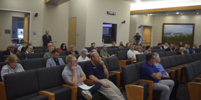 Miembros del Concejo Municipal de Normal sentados en una sala de reuniones, durante la votación de una ordenanza sobre alquileres a corto plazo.