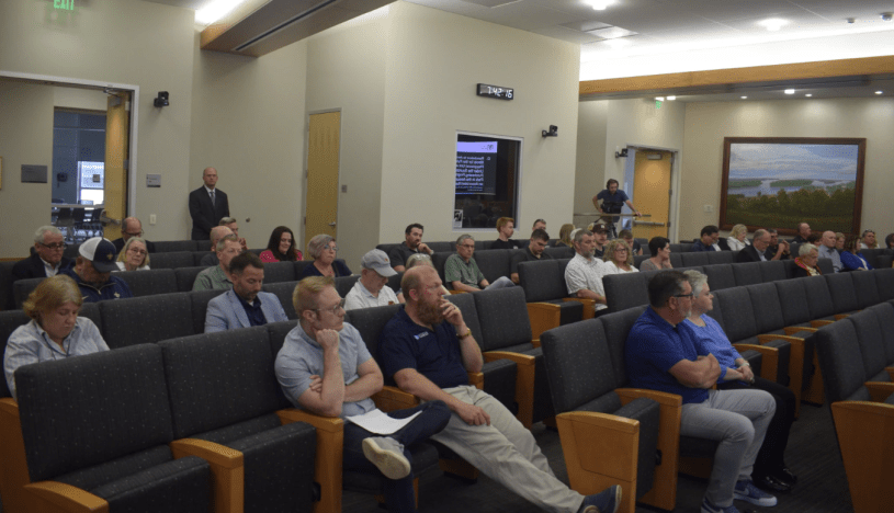 Miembros del Concejo Municipal de Normal sentados en una sala de reuniones, durante la votación de una ordenanza sobre alquileres a corto plazo.