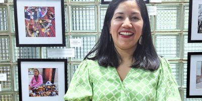 Artista Yolanda Alonso con sus fotografías de fondo.