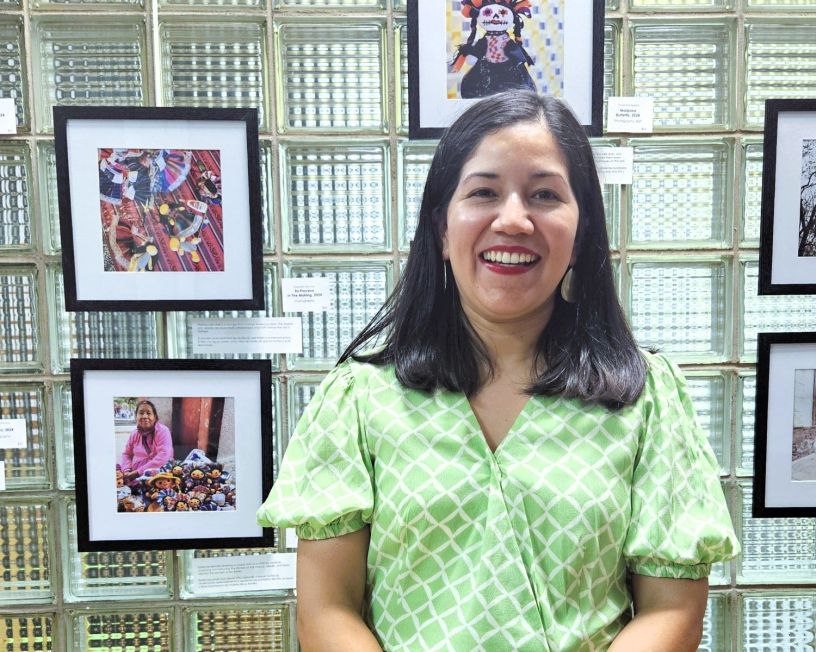 Artista Yolanda Alonso con sus fotografías de fondo.