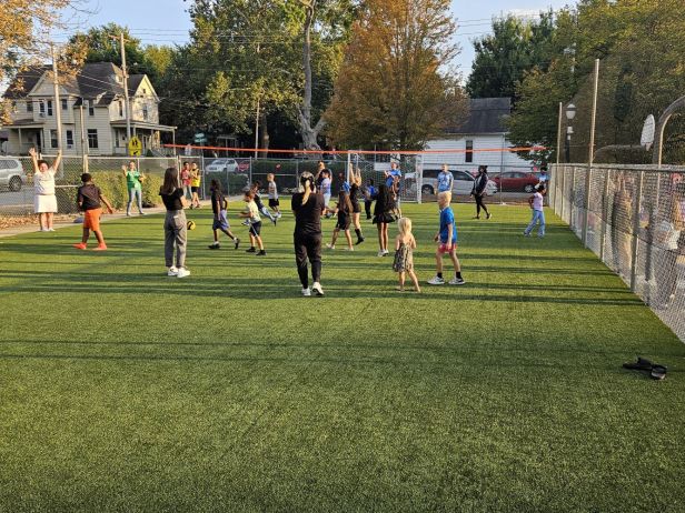 Niños jugando sobre un piso de grama artificial.