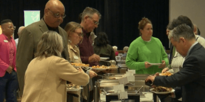 Gente tomando comida de una mesa.