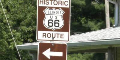 Señal de tránsito anunciando la ruta 66 y una flecha hacia la izquierda.