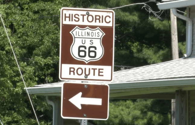 Señal de tránsito anunciando la ruta 66 y una flecha hacia la izquierda.