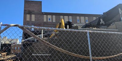 Excavadoras demoliendo un edificio de ladrillo en el centro de Bloomington