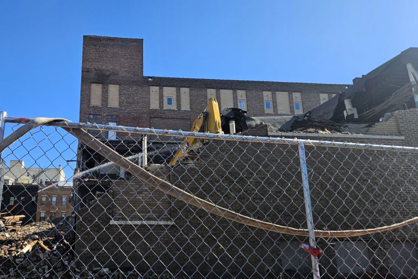 Excavadoras demoliendo un edificio de ladrillo en el centro de Bloomington