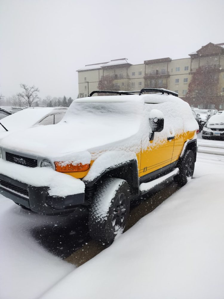 Un carro estacionado cubierto de nieve.
