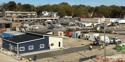 Vista de las cabinas individuales del albergue The Bridge en construcción, con voluntarios pintando las estructuras.