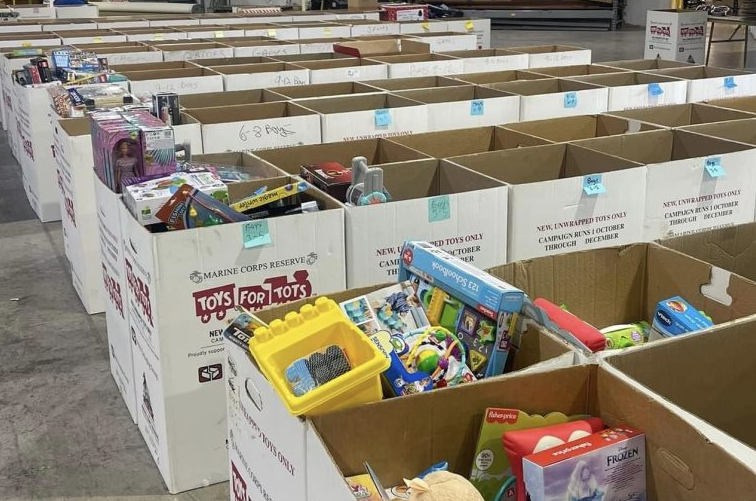 Voluntarios clasifican juguetes nuevos en una mesa durante la campaña Toys for Tots en Bloomington.