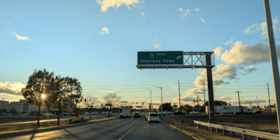 Una avenida sin vehículos con una señal de tránsito que dice Veterans Parkway.