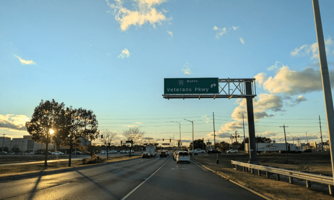 Una avenida sin vehículos con una señal de tránsito que dice Veterans Parkway.