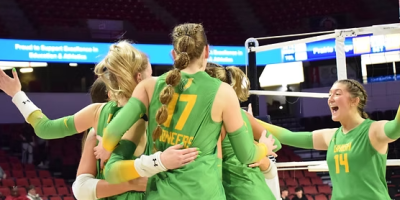 Jugadoras de U-High celebran en la cancha tras ganar el campeonato estatal de voleibol en CEFCU Arena.