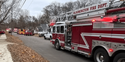 Bomberos frente a una casa con daños por incendio en Eastholme Avenue, en Bloomington.