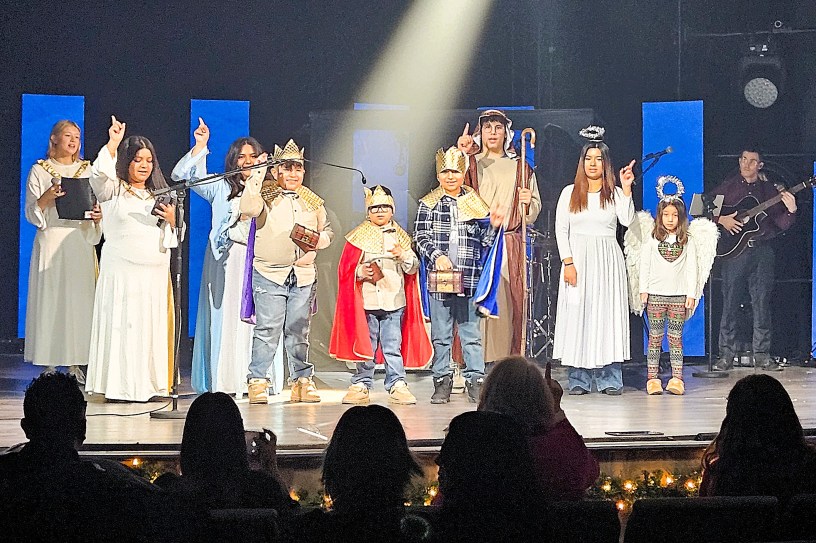 Niños vestidos con disfraces sobre el escenario, representando el nacimiento de Jesús.