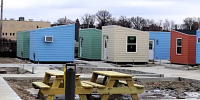 Instalaciones del refugio The Bridge en Bloomington con cabañas y áreas comunes en etapa final de preparación.