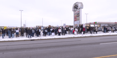 Personas con pancartas protestan pacíficamente contra ICE a lo largo de Veterans Parkway en Bloomington.