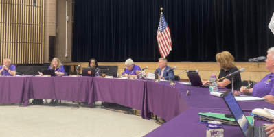 Consejo escolar reunido en una sesión. sentados en mesas alineadas en semicirculo